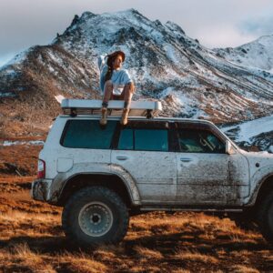 A woman sitting on top of a car